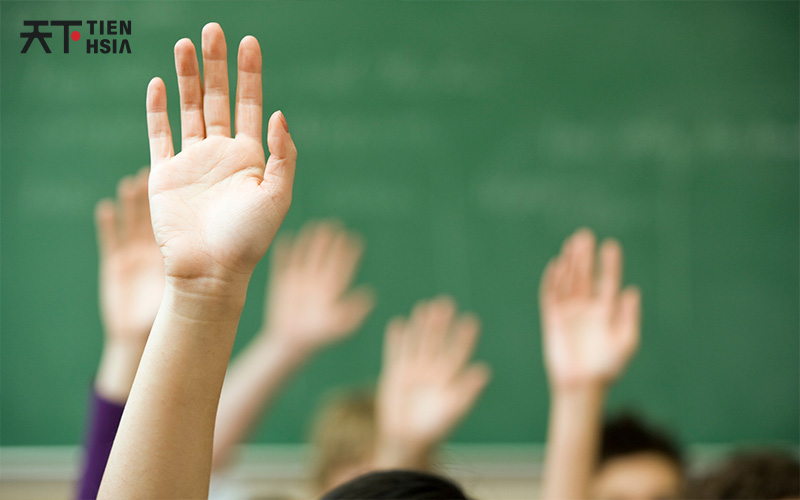 Students raising their hands in class
