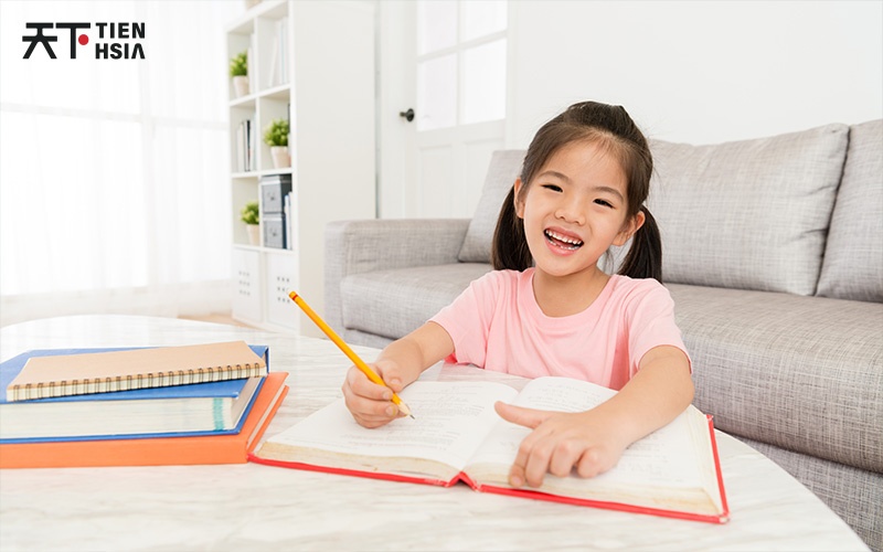 Kid smiling widely while studying