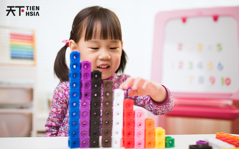 Child learning math with building blocks in an enrichment class.