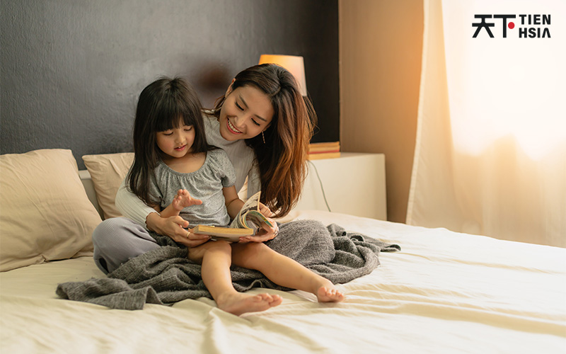 Tien Hsia mother and daughter reading a book together.