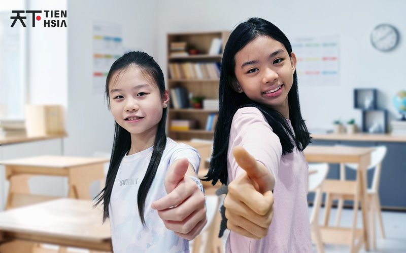 Two Smiling Upper Primary students giving a Thumbs Up