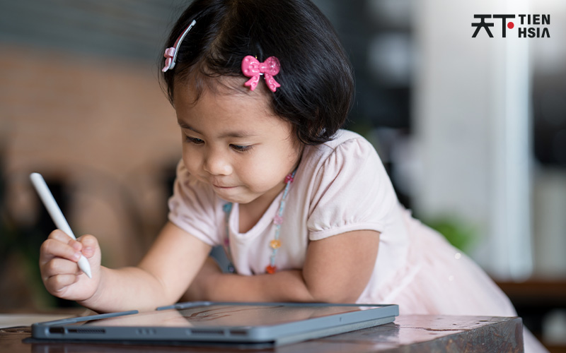 Young child learning with a tablet in an enrichment class.