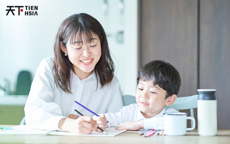 Mother guiding a child in Chinese calligraphy practice.